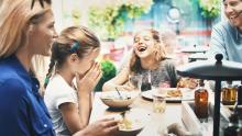 une famille rigolant à table